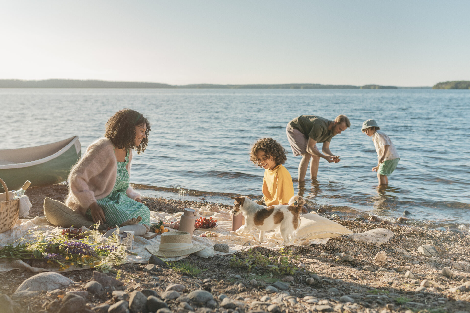 Perhe viettämässä kesäpäivää rannalla